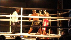 Themba Shicila throws a punch while referee Cliford Mbelu watches.